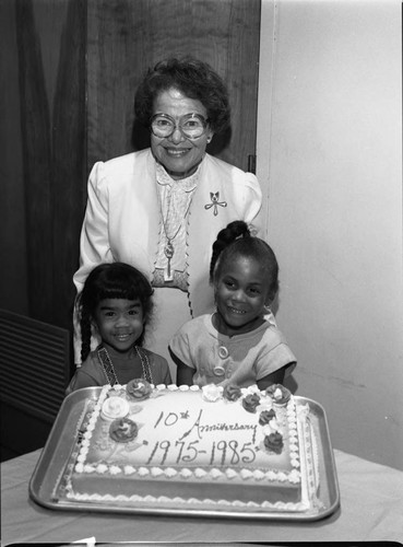 AKA U.N. Marrob Forum participant Ruth Washington and children posing with a cake, Los Angeles, 1985