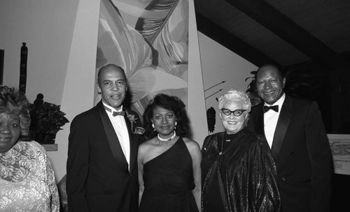 Tom Bradley posing with others during a formal event, Los Angeles, 1990