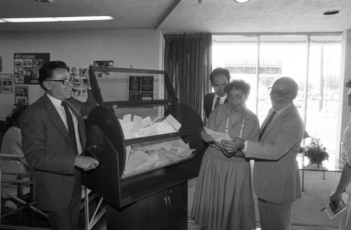 Elbert T. Hudson, Rita M. Hill, and Willis K. Duffy selecting a raffle winner, Los Angeles, 1987