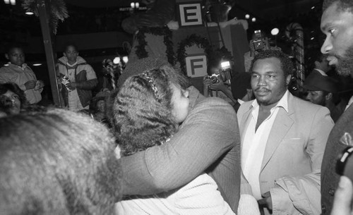 African American man greeting a woman with a hug at Fox Hills Mall, Los Angeles, 1982