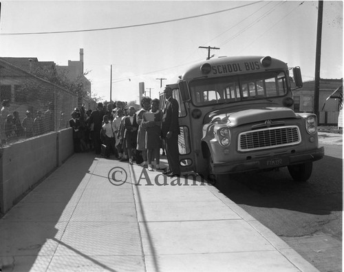 Children entering a school bus, Los Angeles, 1963