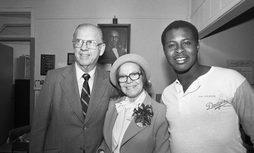 Kenneth Hahn and Ruth Washington posing with a member of the Los Angeles Dodgers, Los Angeles, 1982