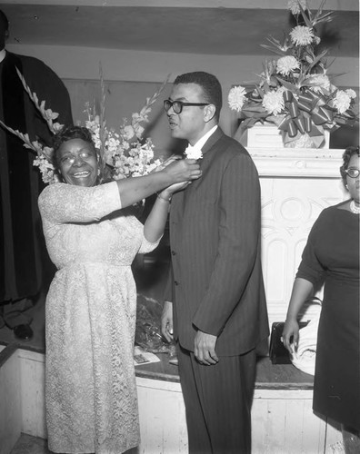 Fanny Benjamin pinning on a young man's boutonniere, Los Angeles, 1961