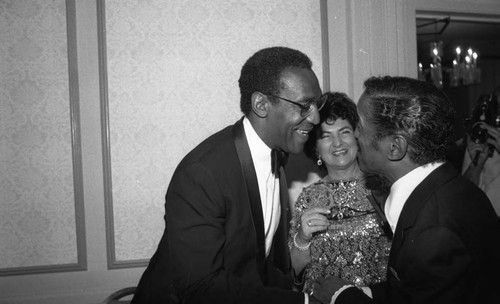 Bill Cosby greeting Sammy Davis Jr. at a formal event, Los Angeles, 1983