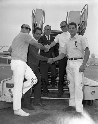 Men shaking hands at airport, Los Angeles, 1968