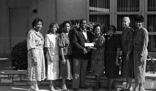 African American man posing as he receives an award, 1989