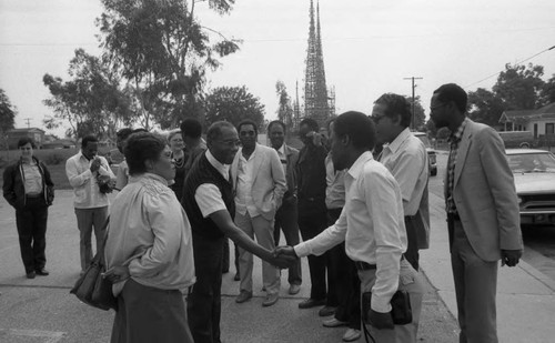 John Outterbridge greeting a man at Watts Towers, Los Angeles, 1985