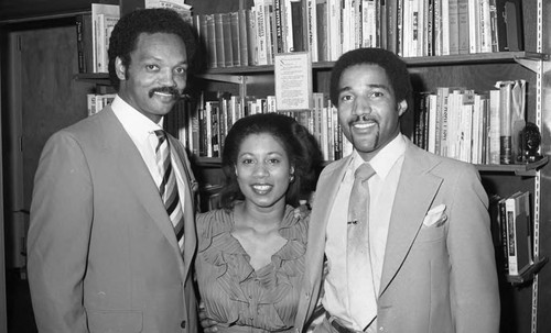 Rev. Jesse Jackson posing with an unidentified couple, Los Angeles, 1983