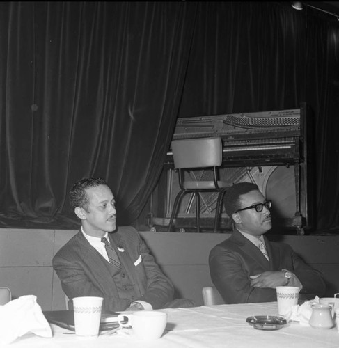 Channing E. Phillips and an unidentified man sitting at a table during a campaign event for Tom Bradley, Los Angeles, 1969