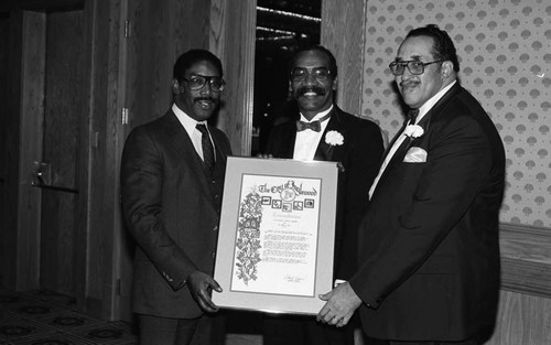 Rev. Wayne S. Davis receiving a commendation from Edward Vincent at a First Apostolic Church event, Inglewood, 1986