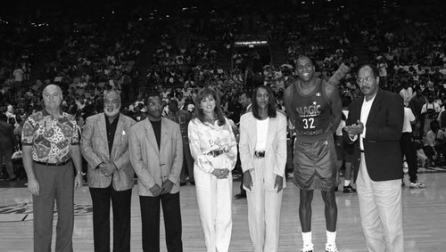 Magic Johnson posing with others at the Great Western Forum, Inglewood, 1994