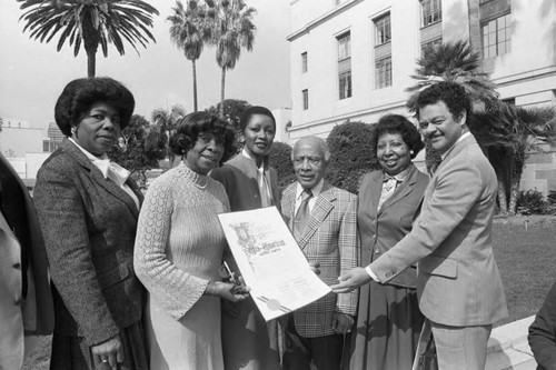 Gilbert Lindsey, Robert Farrell and others posing with a Black History Month proclamation, Los Angeles, 1982