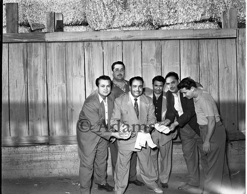 Men hold money and ticket stubs, 1954