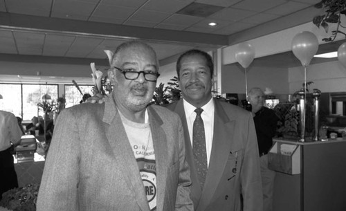 Frank Holoman posing with Celes King III at the opening of the restaurant Frank's Place, Los Angeles, 1998