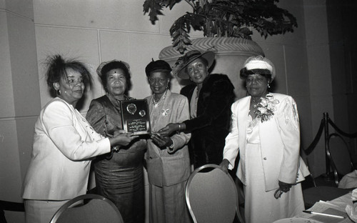 Alpha Chi Psi Omega members posing with an award, Los Angeles, 1989