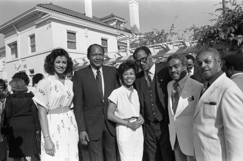 Tom Bradley posing with Veronica Ali and others at an outdoor event, Los Angeles, 1981 ca