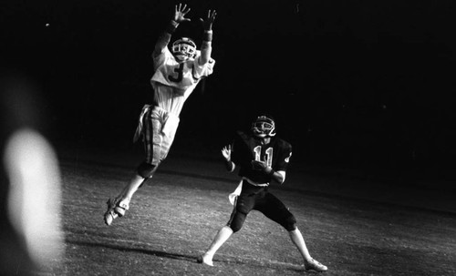 Crenshaw High School football player leaping for the ball, Long Beach, California, 1982