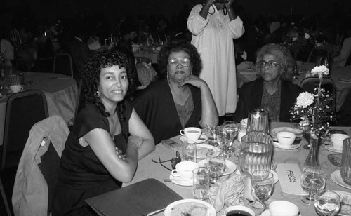 Three women posing together at a formal dinner, Los Angeles, 1983