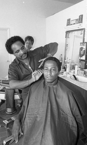 Hairdresser styling his client's hair, Los Angeles, 1984