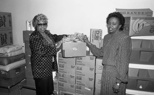 Mayme G. Davis posing near food crates during a Los Angeles Urban League Head Start event, Los Angeles, 1987