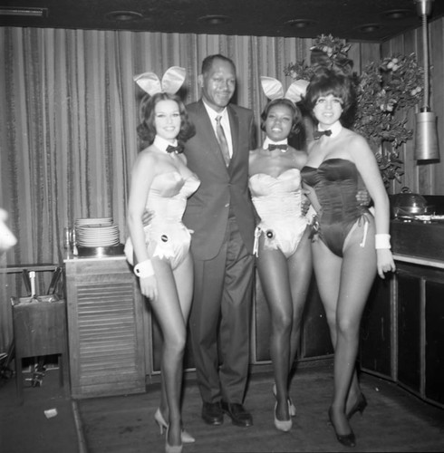 Tom Bradley posing with Playboy Bunnies at a mayoral campaign event,, Los Angeles, 1969