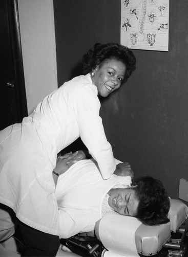 Woman performing a treatment at the Family Chiropractic Services Clinic, Los Angeles, 1984