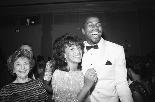 Magic Johnson posing with an unidentified woman at his birthday party, Los Angeles, 1985