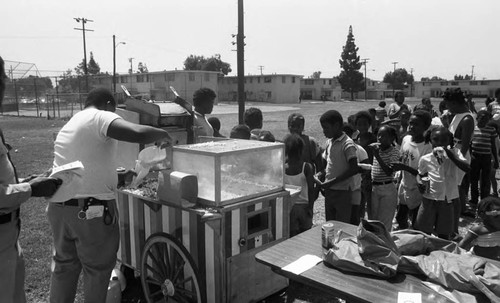Children lining up for popcorn at a Nickerson Gardens picnic, Los Angeles, 1985