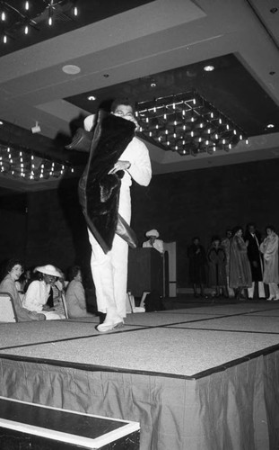 Alpha Phi Alpha fashion show male model displaying a fur-lined coat, Los Angeles, 1985