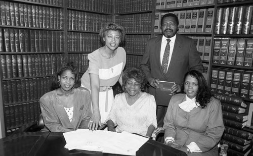 Margo Bouchet poses with others in a law office library, Los Angeles, 1989