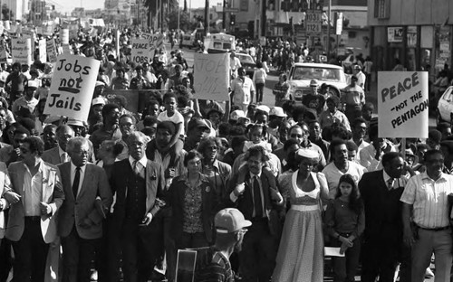 Community leaders marching with a crowd during a birthday celebration for Dr. Martin Luther King, Jr., Los Angeles, ca. 1987