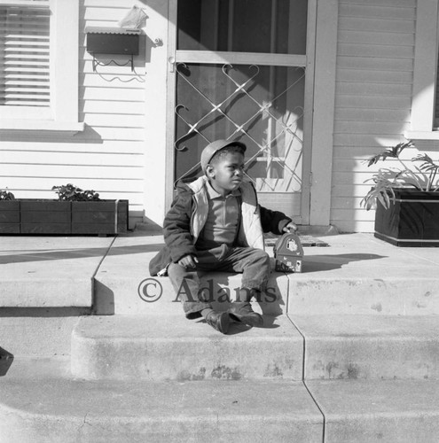 Child on porch steps, Los Angeles, 1963