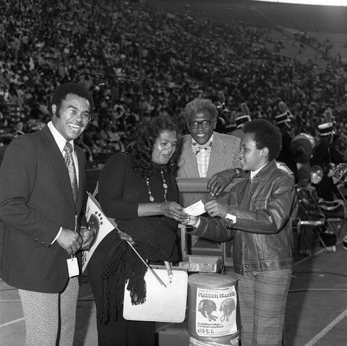 Winner of the Los Angeles Urban League Celebrity All-Star Freedom Classic pre-game drawing receiving her prize, Los Angeles, 1973