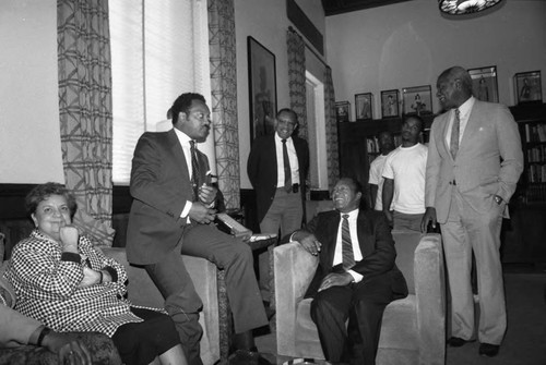 Rev. Jesse Jackson, Mayor Tom Bradley, Nat Holden and others talking in the mayor's office, Los Angeles, 1988