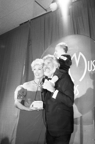 Kenny Rogers, Marianne Gordon, and Christopher Cody Rogers posing at the American Music Awards, Los Angeles, 1983