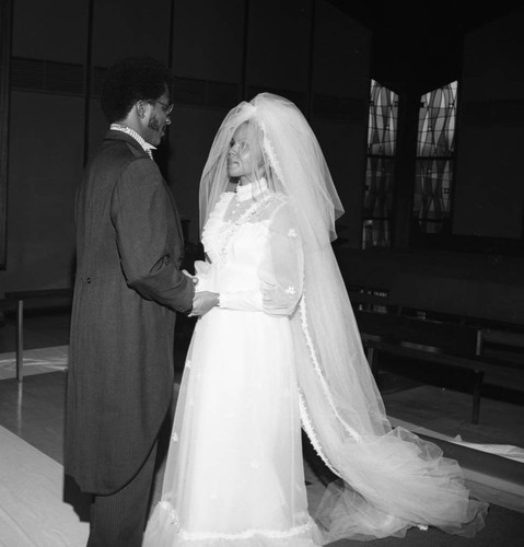 Bride and groom standing at the altar of a church during their wedding, Los Angeles, 1972