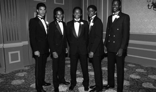 Debutante escorts posing together in a ballroom, Los Angeles, 1984