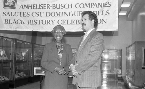 Mick Lewis standing near an exhibit during a Black History event at California State University, Dominguez Hills, Los Angeles, 1988