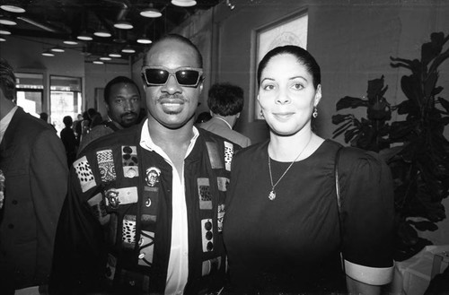 Stevie Wonder posing with a woman at a press conference, Los Angeles, 1989