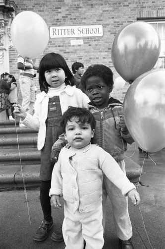 Children holding balloons at Ritter Elementary School, Watts (Los Angeles, Calif.), 1983