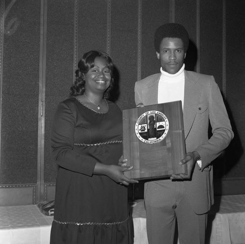 Mary Lee Baker presenting a plaque to Compton College basketball player Al Forney, Hawthorne, California, 1973