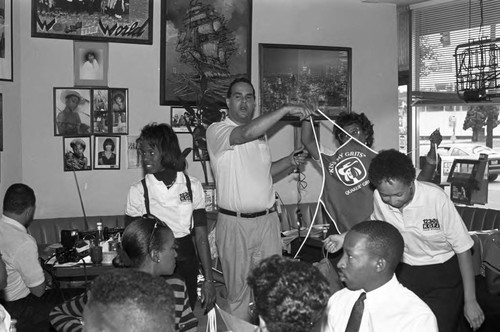 KGFJ Soul Search staff talking with others at a cafe, Los Angeles, 1975