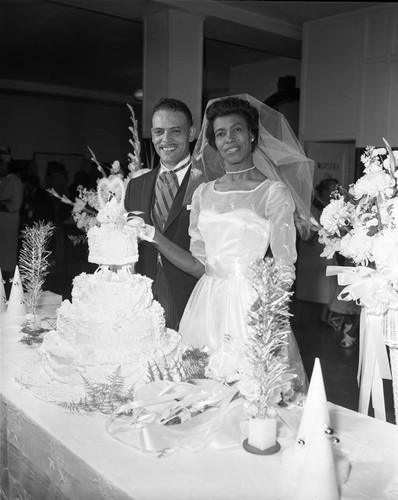 Rev. and Mrs. Sewell Bridges posing with their wedding cake, Los Angeles, 1962