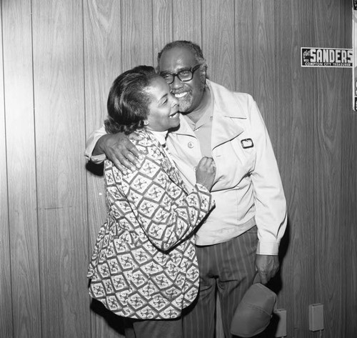 Couple hugging during election night, Compton, 1975