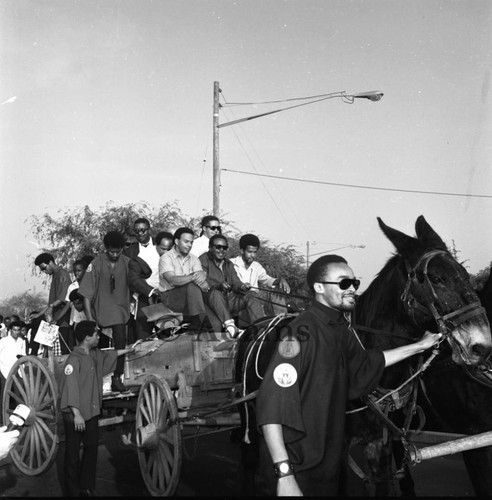 Andrew Young, Ralph Abernathy and others riding on a wagon in the Watts parade, Los Angeles, 1966