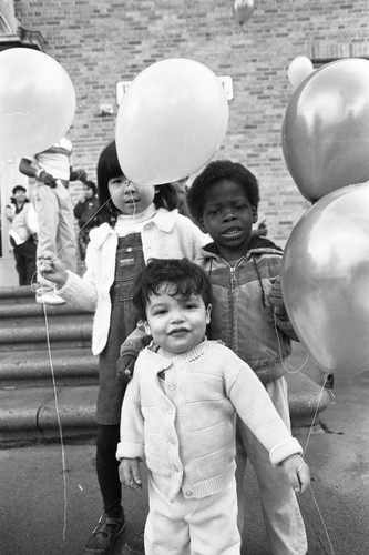 Children holding balloons at Ritter Elementary School, Watts (Los Angeles, Calif.), 1983