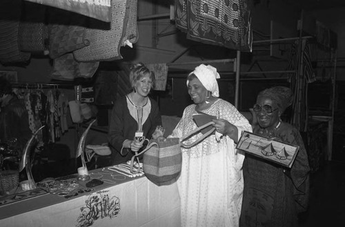 Woman exhibiting items in her booth during the annual African festival, Los Angeles, 1986