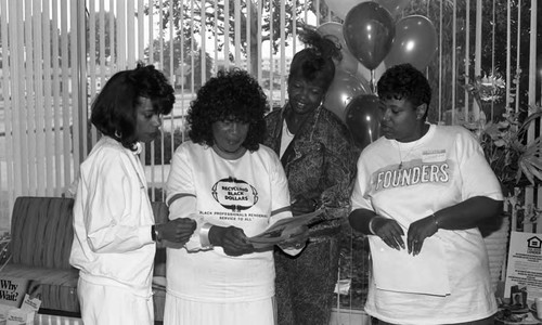 Women examining documents at Founders Savings and Loan, Los Angeles, 1989