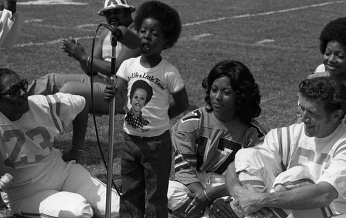 Rodney Allen Rippy leading a song during the Urban League's Celebrity All-Star Freedom Classic pre-game, Los Angeles, 1973
