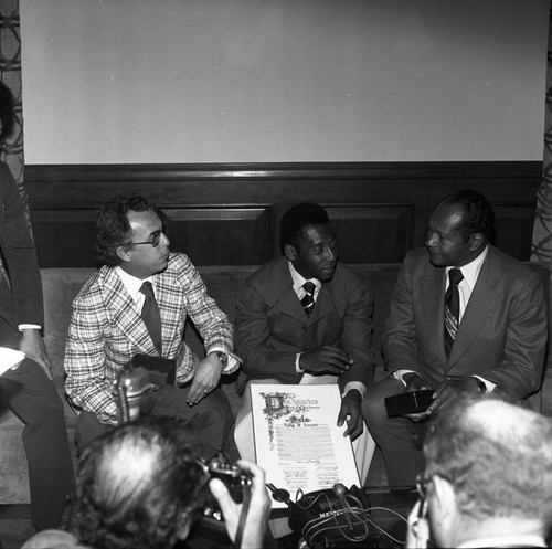 Pelé holding a commendation and speaking with Mayor Tom Bradley, Los Angeles, 1975